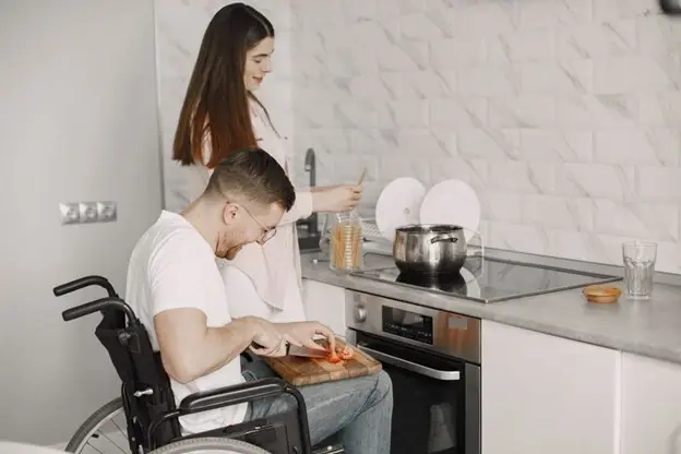 A couple cooking together in a modern, accessible kitchen designed with universal design principles for ease of use and inclusivity.