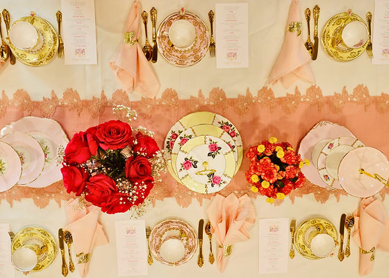Elegant tea party setup with floral decor, teapots, and vintage-inspired tableware