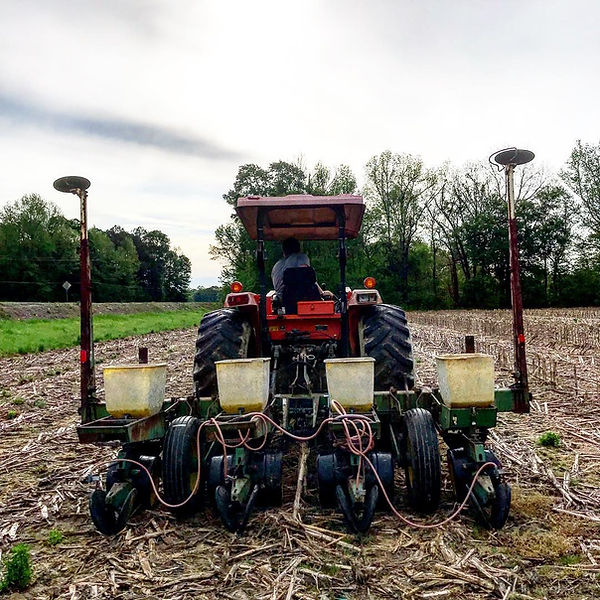 Rob Jones a land salesman is planting corn on a tractor.
