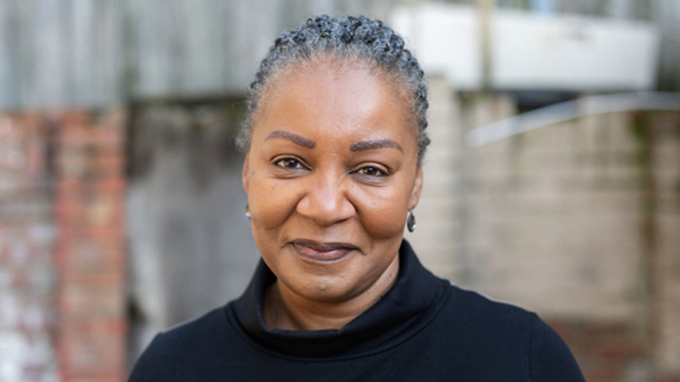 Attractive black woman wearing black facing the camera smiling