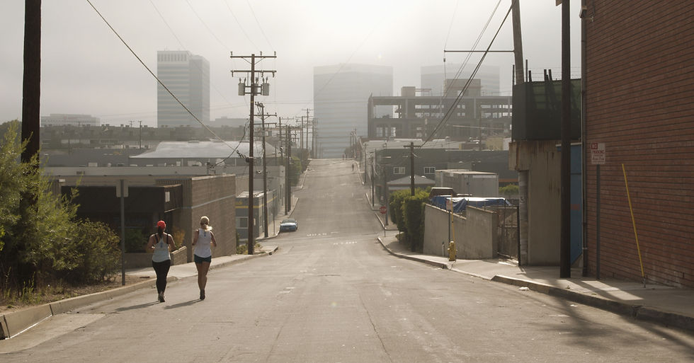 Two woman jog down an empty street together during early-morning hours