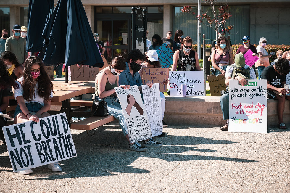 Protesters in masks bow their heads in silence outside the Civic Center in El Segundo, California