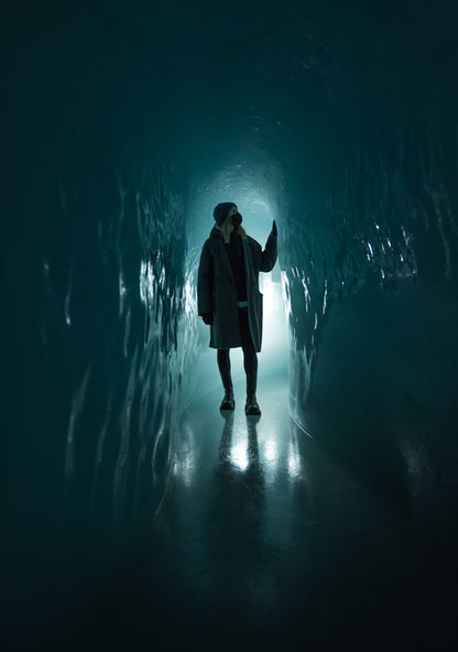 Eine Frau in einer Blauen Eisgrotte auf dem Jungfrau Joch