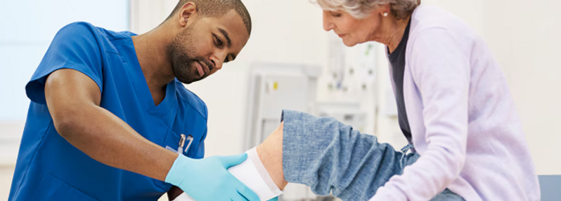 nurse assisting with dressing change