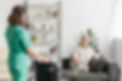 nurse-bringing-wheelchair-her-senor-female-patient-sitting-couch.jpg