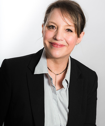 headshot of a smiling woman wearing a blazer and blue pinstriped shirt with her hair pulled back