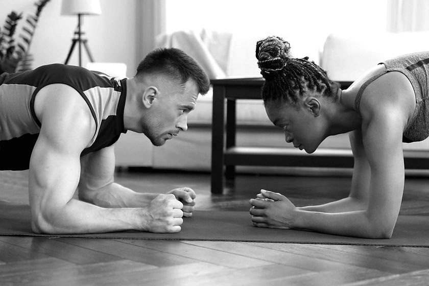 Man and woman challenging eachother in a plank hold