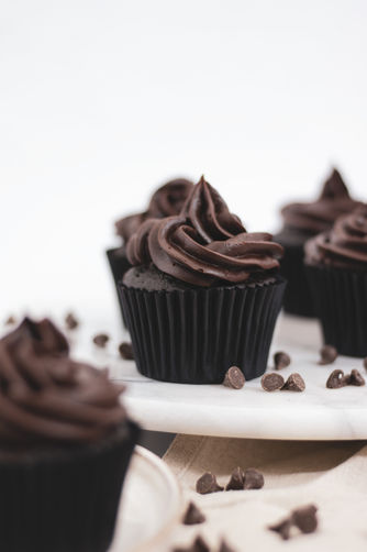 chocolate cupcakes on a cake stand with chocolate chips