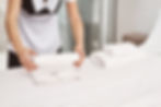 Reinigungskraft säubert Schlafzimmer in einer Ferienwohnung