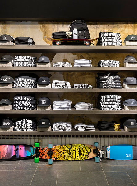 Detail eines Ladeninterieur mit Skaterkleidung und Skateboards auf Regalen.