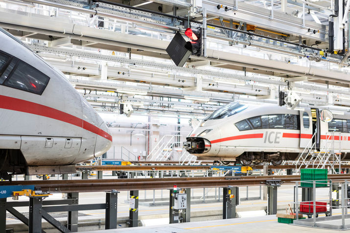 Riesige Halle mit zwei ICE Zügen auf hochgelegten Gleisen