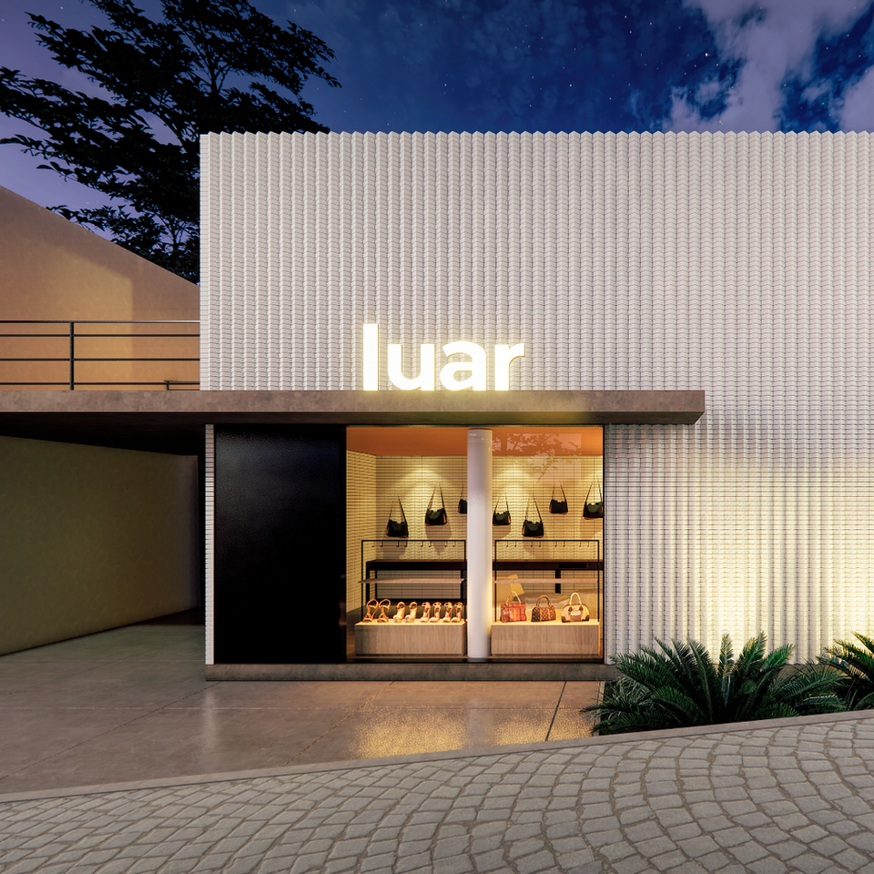 Fachada de Loja em tijolo branco assentado irregularmente, letreiro iluminado escrito luar