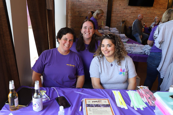 Volunteers wearing purple and grey Finley Forever merchandise