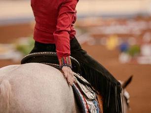 Frau mit roter Bluse sitzt auf Quarter Horse, Westernsattel