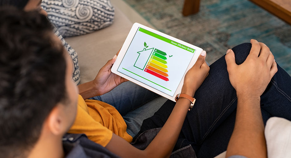 Rear view of indian couple checking on digital tablet housing energy efficiency rate. Husb