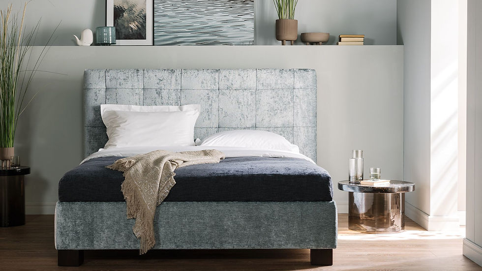 Stilvolles Schlafzimmer: Bett mit gepolstertem Kopfteil und dunkler Bettdecke