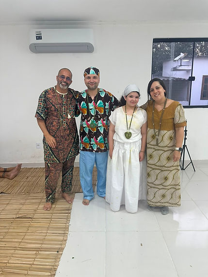 Registro de um encontro de Ifá, com quatro pessoas reunidas e fios de contas.