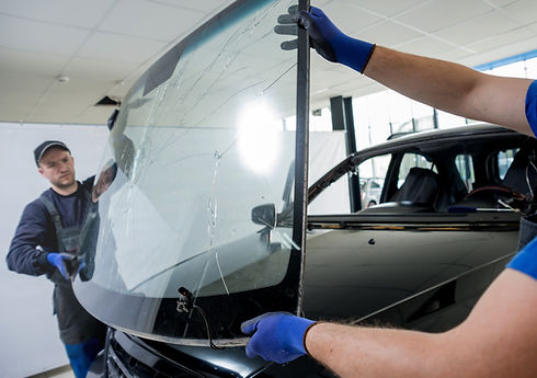 Automobile special workers remove old windscreen or windshield of a car in auto service st