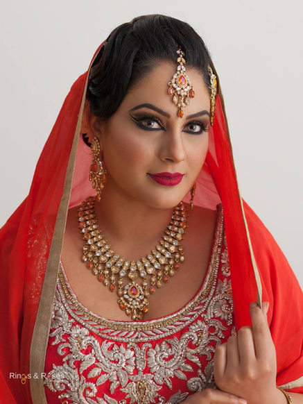 Beautiful Indian bride wearing red dress with golden jewellery