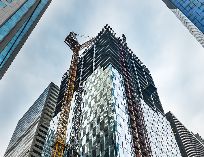 Modern skyscraper under construction, city backdrop