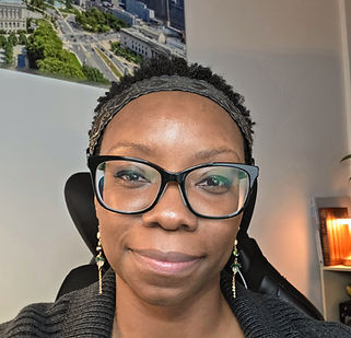 40 year old Black American woman with glasses and short natural hair. Looking at camera with friendly smile.