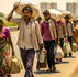 “Group of Indian migrant workers walking on a highway with bags and children, tired faces, hot sun, emotional atmosphere, गरीబు జీవితం, cinematic realistic style, highlighting struggle and dignity of labour”