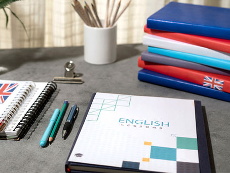 Livros de inglês e cadernos amontados sobre uma escrivaninha