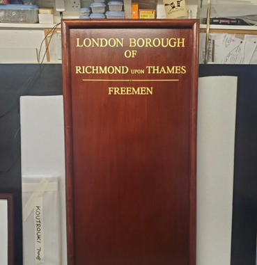 wooden board with gold gilded names