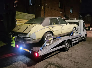 Car being towed by white recovery vehicle