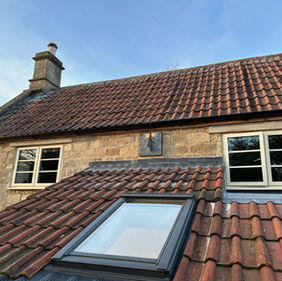 New roof installed with roof windows and dark red tiles