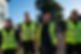 4 men walking and smiling with high visibility jackets