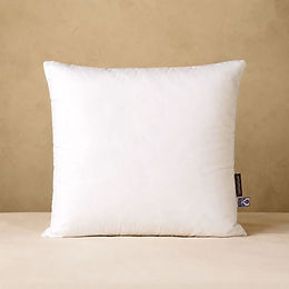 Woolroom wool cushion pad, plain white square pad with a woolroom label, on a tan background