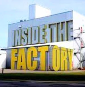 Inside the Factory BBC TV series title shown as large yellow letters on the side of an industrial factory building