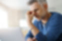 Man at home having a headache in front of laptop.jpg