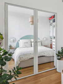 chambre compacte avec dressing, lit coffre, chambre optimisée, dressing ikea, chambre parentale, verrière intérieure, portes vitrées, aménagement petit espace, tête de lit peinte, tête de lit demi-lune vert d'eau, tête de lit arche, décoration scandinave, linge de lit blanc, coussin brodé, dressing ouvert, luminaire design, applique murale, ambiance sereine, décoration minimaliste, appartement moderne, séparation de pièce vitrée, gain de luminosité, parquet en chêne, plantes d'intérieur, style contemporain