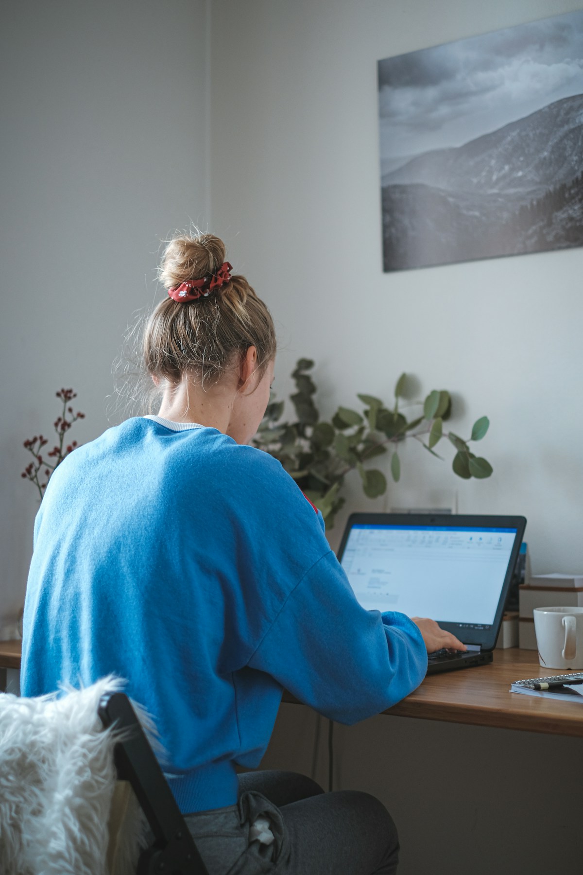 Self-employed home buyer reviewing mortgage documents on a laptop while preparing to buy a home in Lakewood, CO
