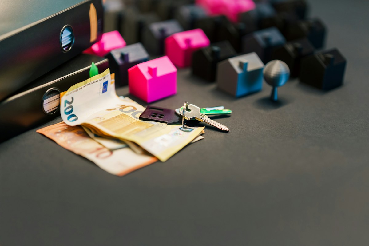 Miniature house, keys, and cash representing seller concessions when selling a home in Lakewood, CO