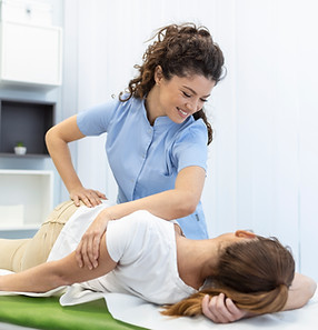young-woman-doctor-chiropractor-osteopath-fixing-lying-womans-back-with-hands-movements-du