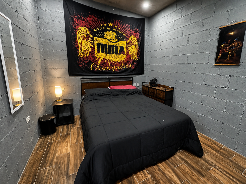 Room at Boxing Camp Mexico with MMA banner and black bed