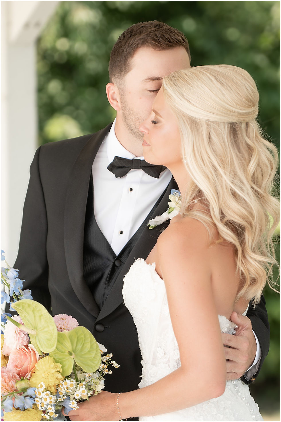 Romantic photo of groom kissing brides cheek