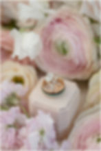 wedding rings surrounded by pink and white flowers