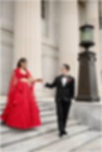 Bride and groom walking down the front steps of the Indianapolis Central library on wedding day