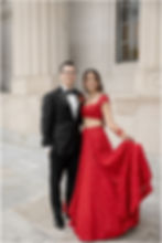Bride in a red lehenga and groom in a black tuxedo for wedding photos at the Indianapolis Central Library