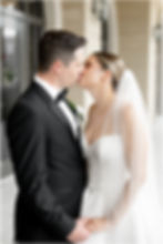 Bride and groom kissing on balcony of Hotel Carmichael in Carmel Indiana