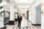 Bride and groom walking though lobby of Hotel Carmichael Autograph Collection in Carmel Indiana