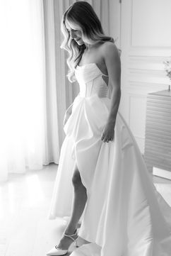 Bride putting on shoes for her Indianapolis wedding in bright hotel suite