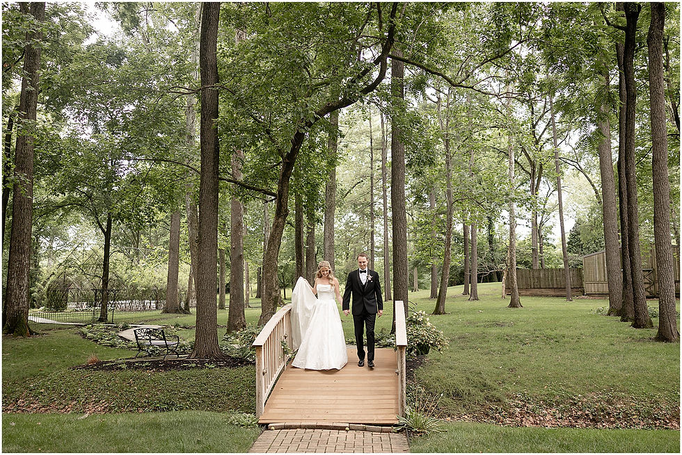 Bride and Groom walking across wooden bridge at Black Iris Estate in Carmel Indiana