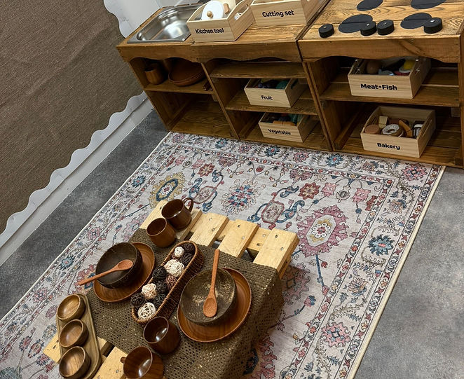 Wooden role-play kitchen and play tables at Hami’s Oriel Street nursery in Bolton