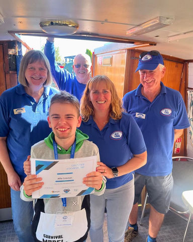 Young man holding certificate, smiling with team