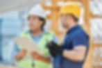 Workers in hi-vis and hard hats in a team discussion